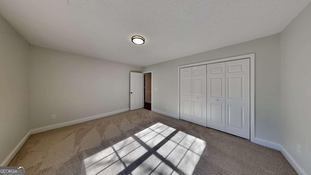 unfurnished bedroom with light carpet, a textured ceiling, and a closet