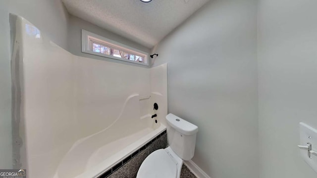 bathroom with toilet and a textured ceiling