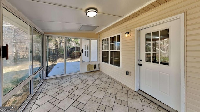 unfurnished sunroom featuring vaulted ceiling and a wall unit AC