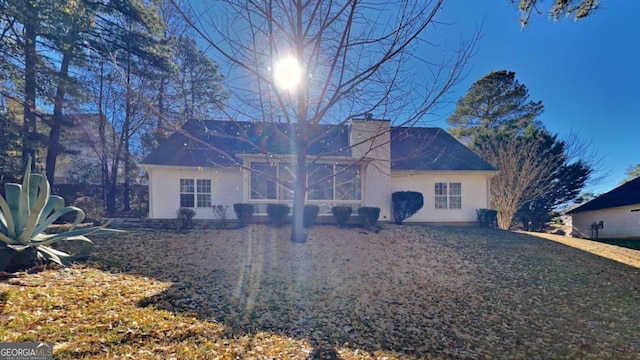 back of property featuring a lawn