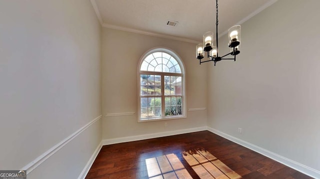 spare room with ornamental molding, dark hardwood / wood-style floors, and an inviting chandelier