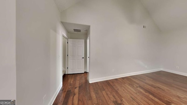 interior space featuring lofted ceiling and dark wood-type flooring