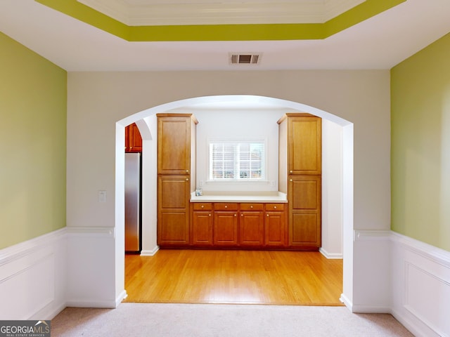 interior space featuring light wood-type flooring and crown molding