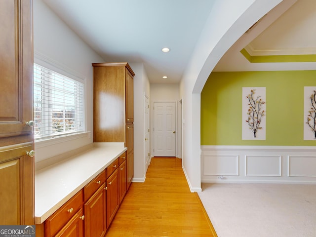 hallway featuring light hardwood / wood-style floors and ornamental molding