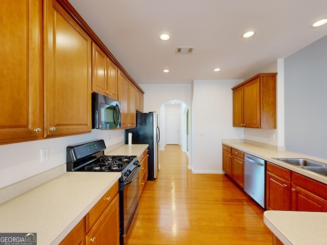 kitchen featuring sink, light hardwood / wood-style flooring, and black appliances