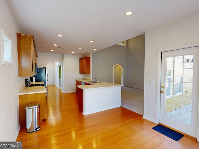 kitchen with kitchen peninsula, light hardwood / wood-style floors, and sink