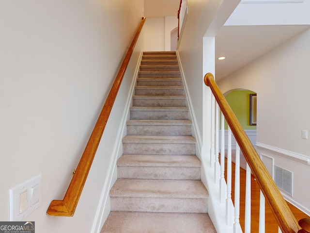 stairs featuring hardwood / wood-style floors