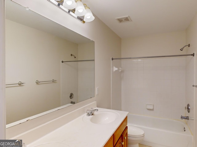 full bathroom with vanity, tiled shower / bath combo, and toilet