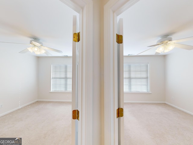 hall with a wealth of natural light and light carpet