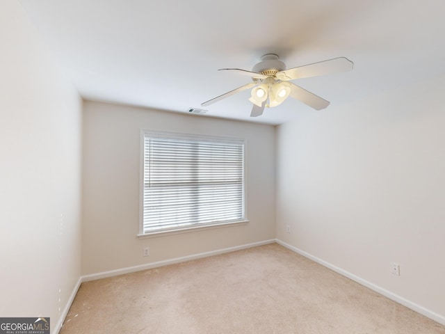 spare room with light colored carpet and ceiling fan