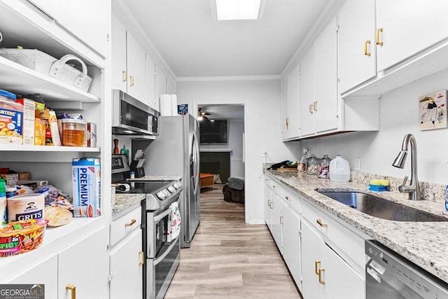 kitchen featuring light wood-type flooring, stainless steel appliances, crown molding, sink, and white cabinets