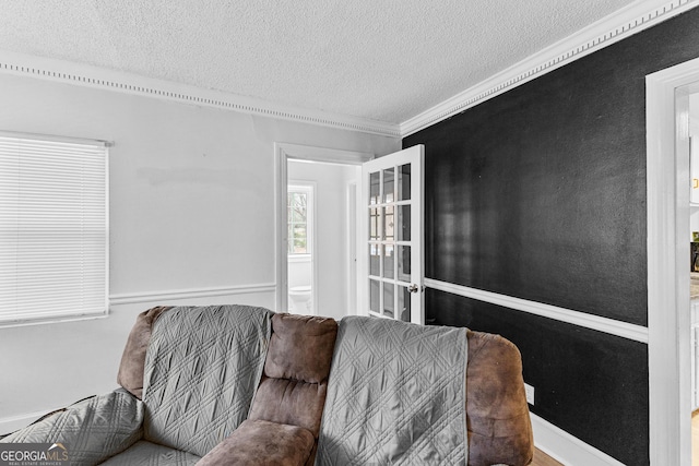 living room with a textured ceiling and crown molding