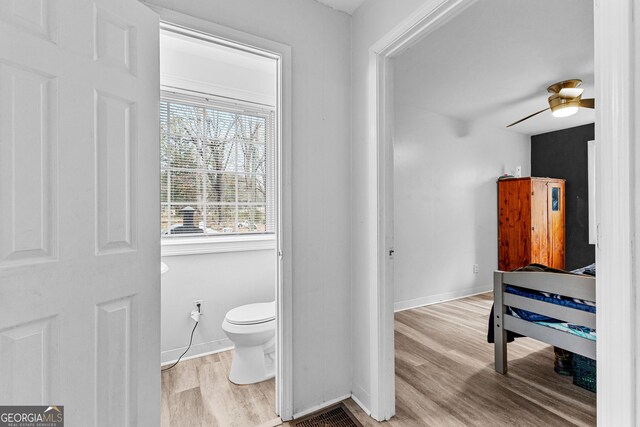 bathroom featuring wood-type flooring, toilet, and ceiling fan