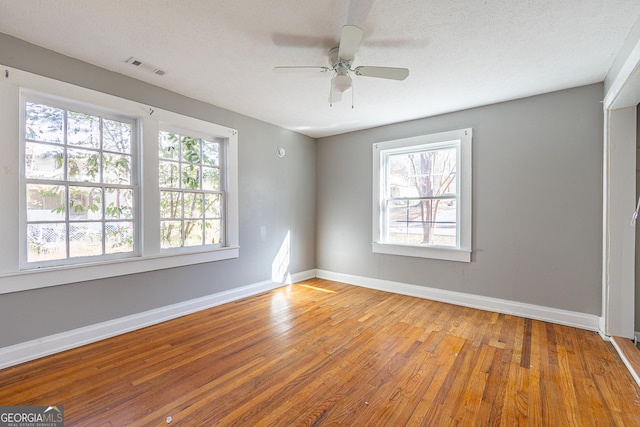 spare room with ceiling fan, wood-type flooring, and a textured ceiling