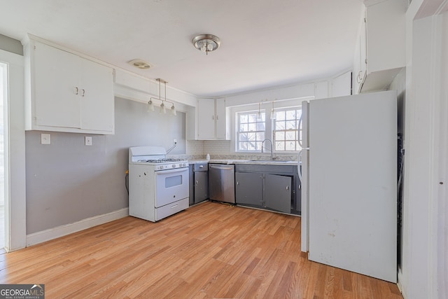 kitchen with white appliances, white cabinets, sink, decorative backsplash, and light hardwood / wood-style floors