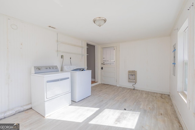 laundry room with heating unit, light hardwood / wood-style floors, and washing machine and clothes dryer