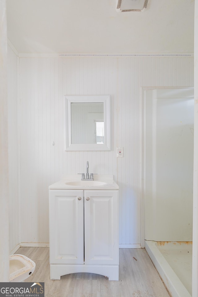 bathroom featuring wood walls, vanity, and wood-type flooring