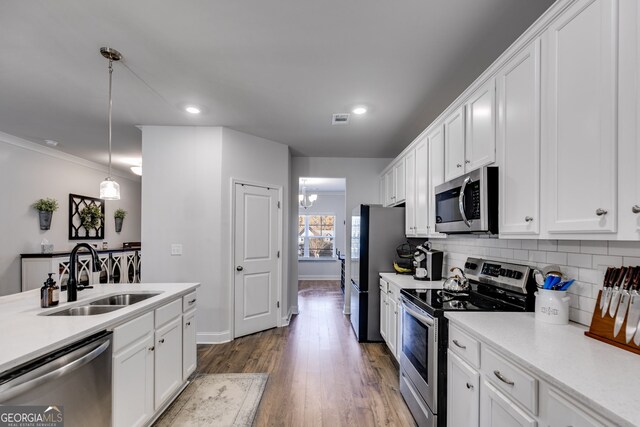 kitchen featuring sink, white cabinets, pendant lighting, and appliances with stainless steel finishes