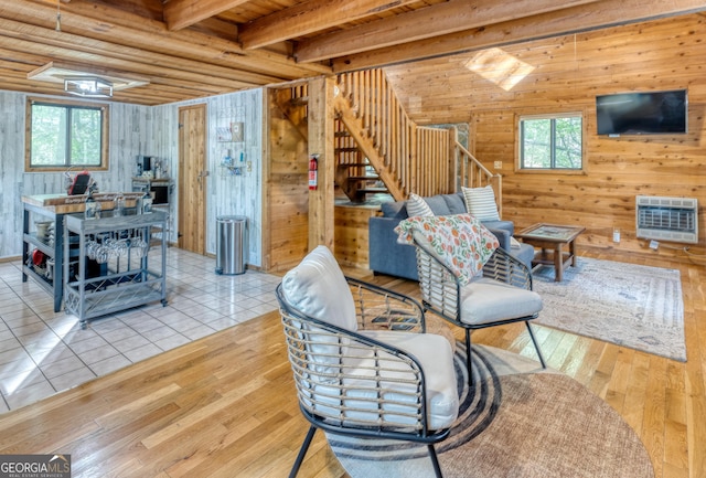 living room with wooden walls, light wood-type flooring, a wealth of natural light, and heating unit