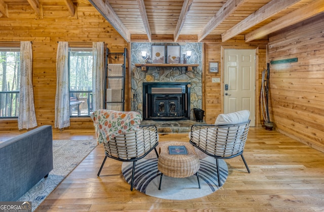 living room featuring beamed ceiling, light hardwood / wood-style floors, wood ceiling, and wood walls