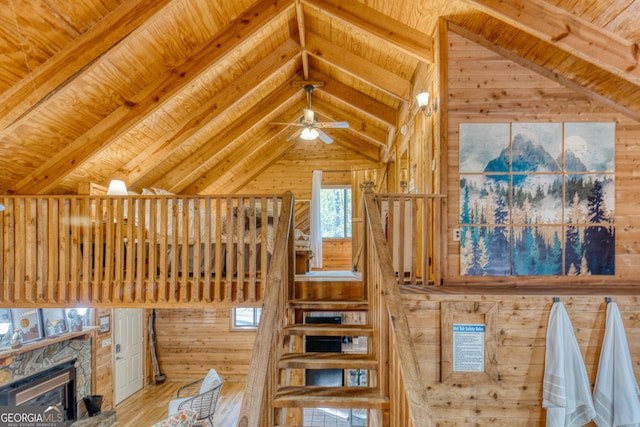 interior space featuring wood ceiling, a fireplace, hardwood / wood-style floors, vaulted ceiling with beams, and wood walls