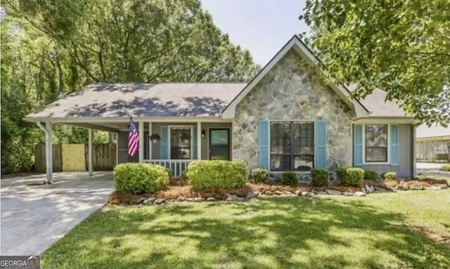 view of front of property featuring a front lawn, covered porch, and a carport