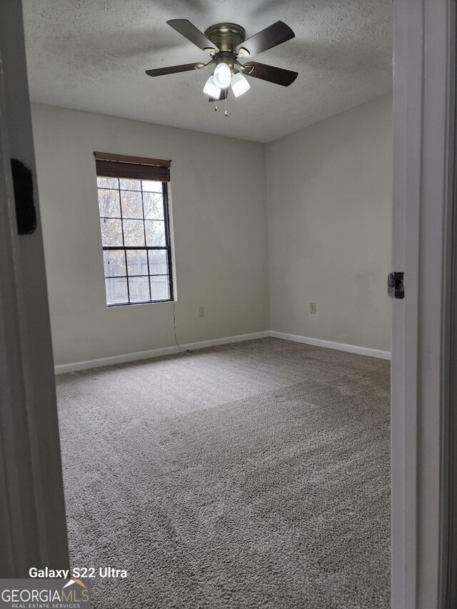 spare room with ceiling fan, carpet, and a textured ceiling