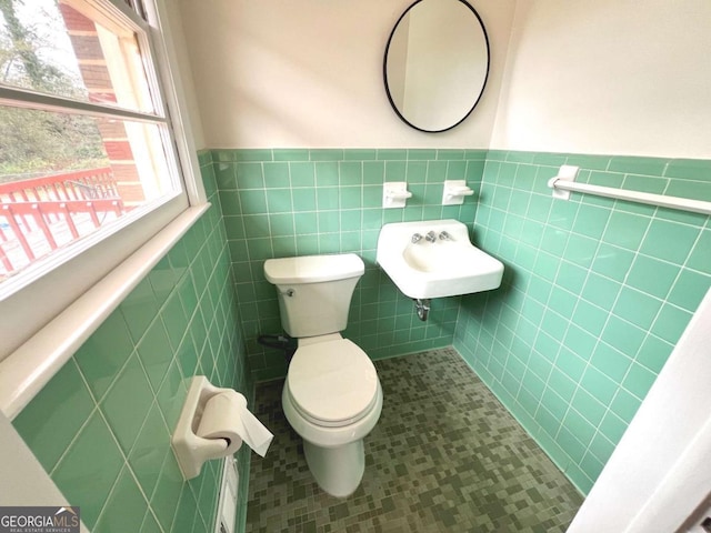 bathroom with tile patterned flooring, tile walls, and toilet