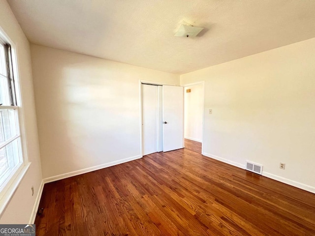 unfurnished room featuring plenty of natural light, hardwood / wood-style floors, and a textured ceiling