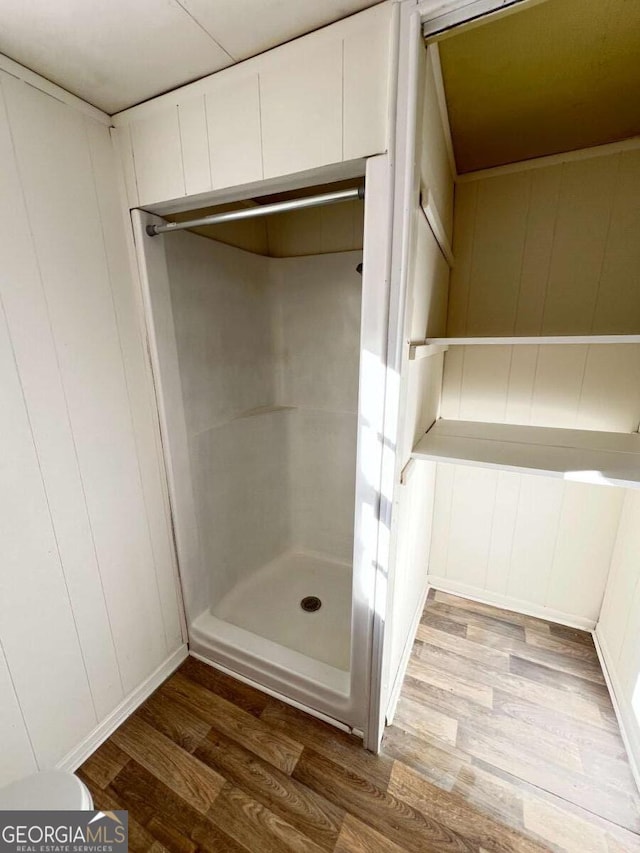 bathroom with a shower and hardwood / wood-style floors