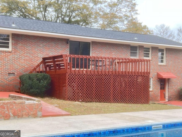 back of property featuring a pool side deck