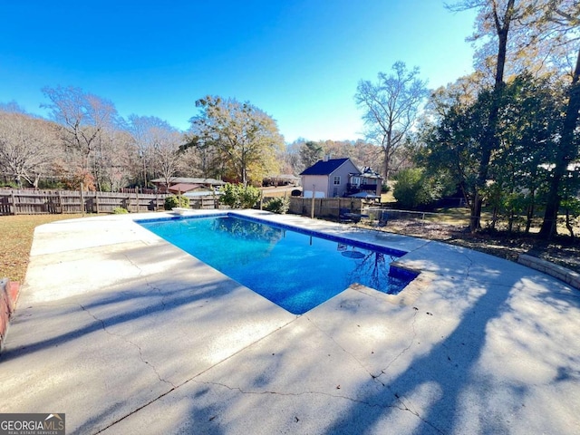 view of swimming pool with a diving board and a patio