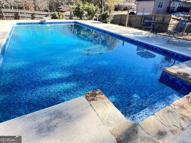 view of pool featuring a patio area and a diving board