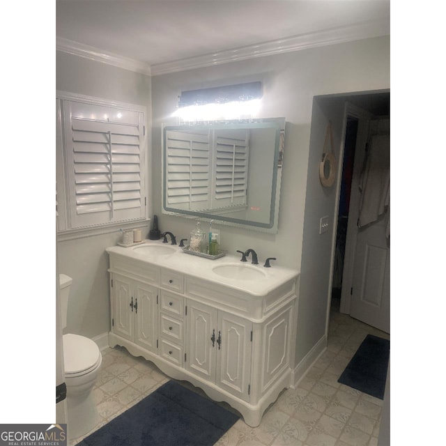 bathroom with vanity, crown molding, and toilet