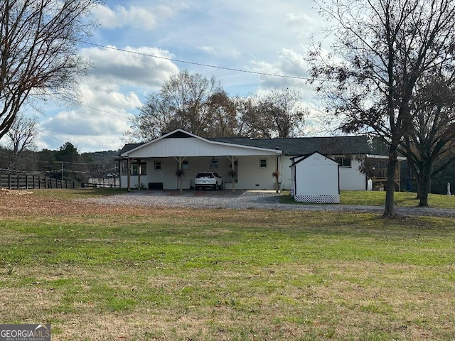 back of property featuring a lawn, a carport, and a storage unit