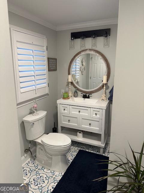 bathroom with vanity, tile patterned floors, ornamental molding, and toilet