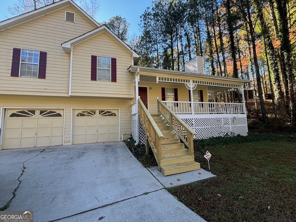 split level home with a front yard, a porch, and a garage