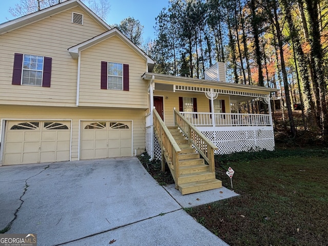 split level home with a front yard, a porch, and a garage