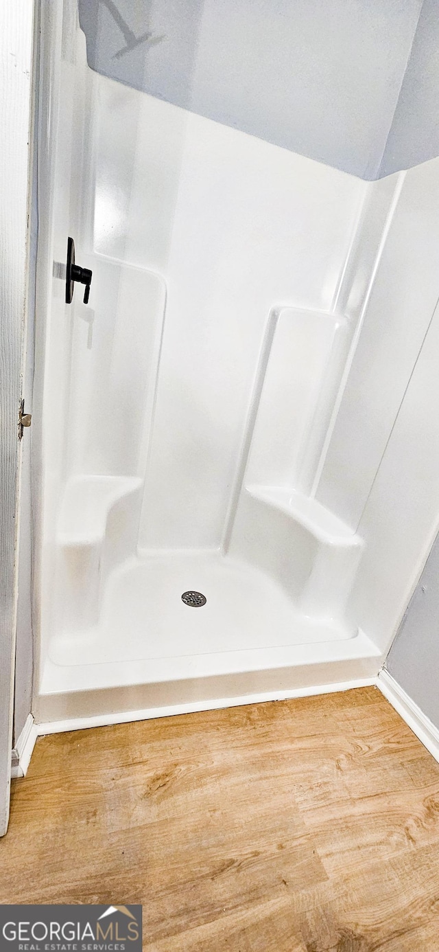 bathroom with wood-type flooring and walk in shower