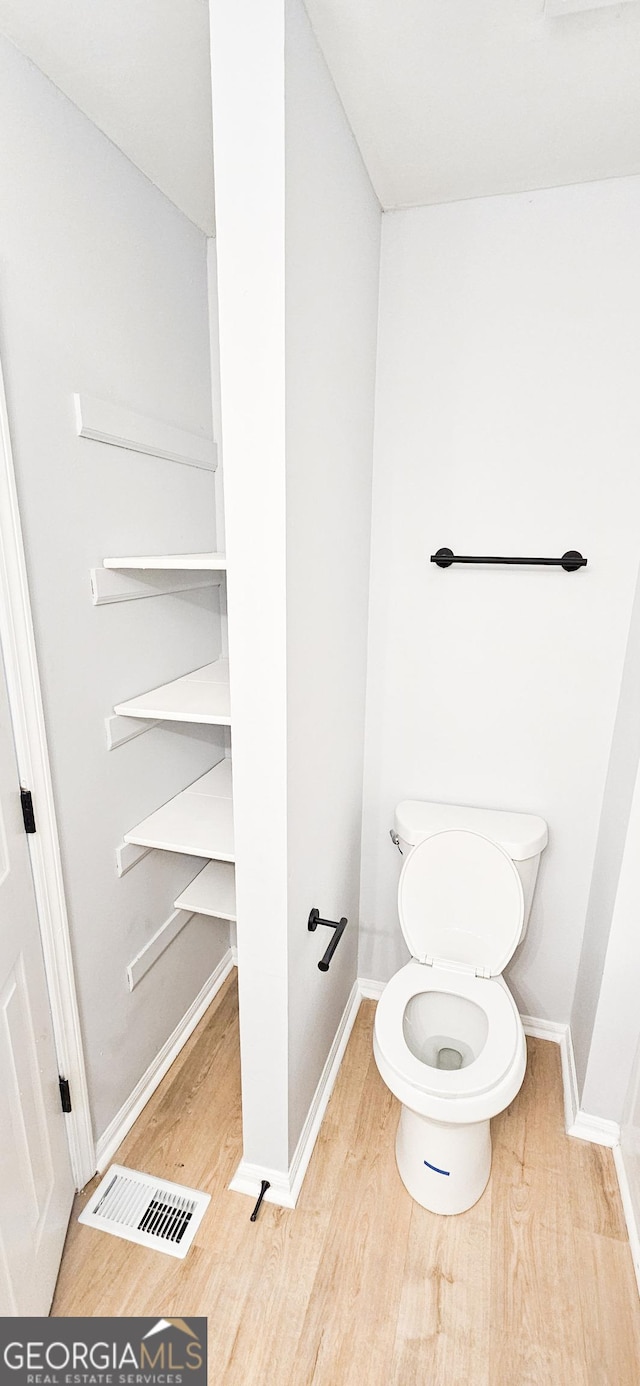 bathroom featuring hardwood / wood-style flooring and toilet