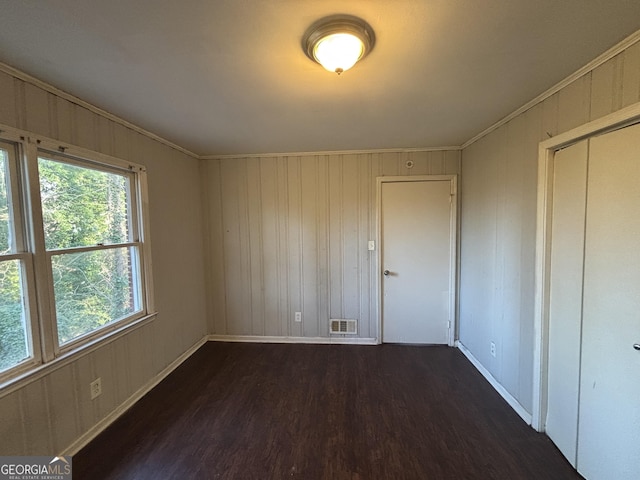 unfurnished room featuring dark hardwood / wood-style flooring and crown molding