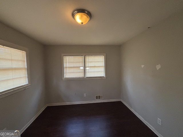 unfurnished room featuring dark wood-type flooring