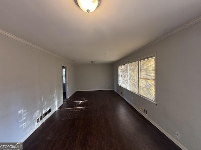 empty room with dark hardwood / wood-style flooring and crown molding