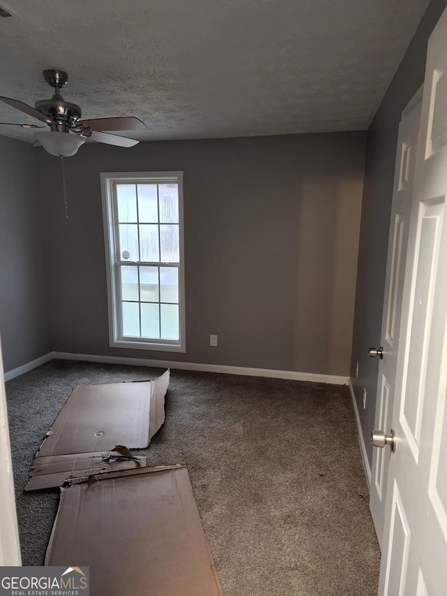 empty room with ceiling fan, carpet, and a textured ceiling