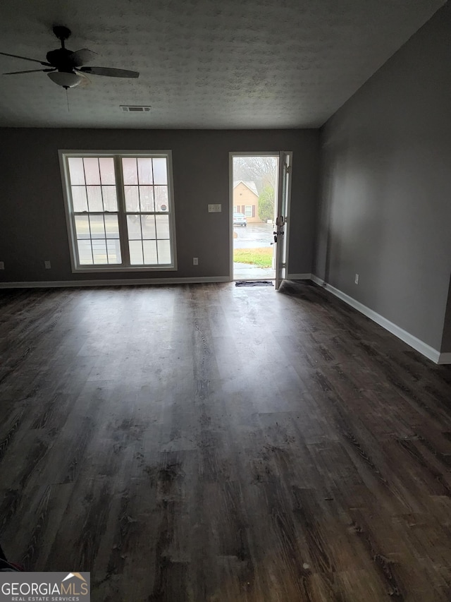 unfurnished room featuring a textured ceiling, dark hardwood / wood-style flooring, and ceiling fan