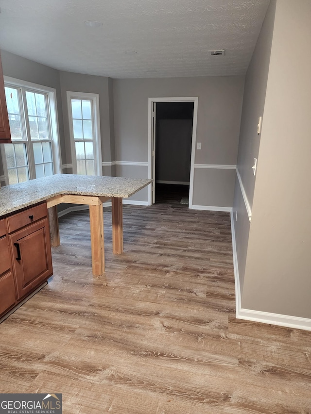 kitchen featuring hardwood / wood-style floors and a textured ceiling