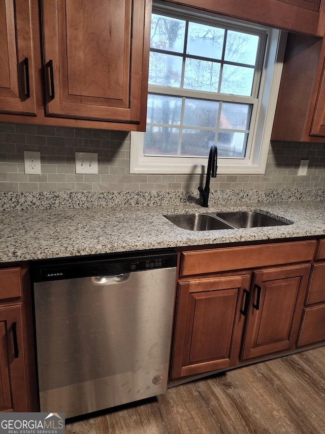 kitchen featuring backsplash, light stone counters, dark wood-type flooring, sink, and dishwasher