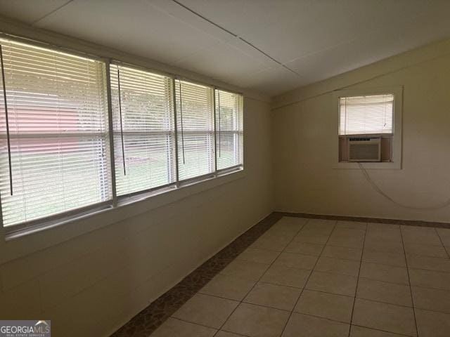 tiled spare room featuring plenty of natural light and cooling unit