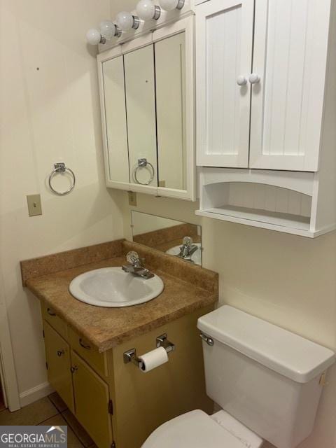 bathroom with tile patterned flooring, vanity, and toilet