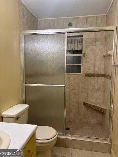 bathroom with tile patterned flooring, vanity, and walk in shower